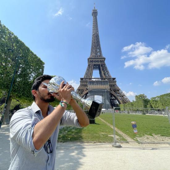 Ayush kissing silver trophy in front of Eiffel Tower