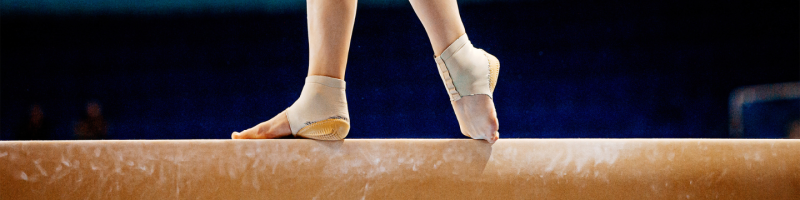 Gymnast feet on wooden beam